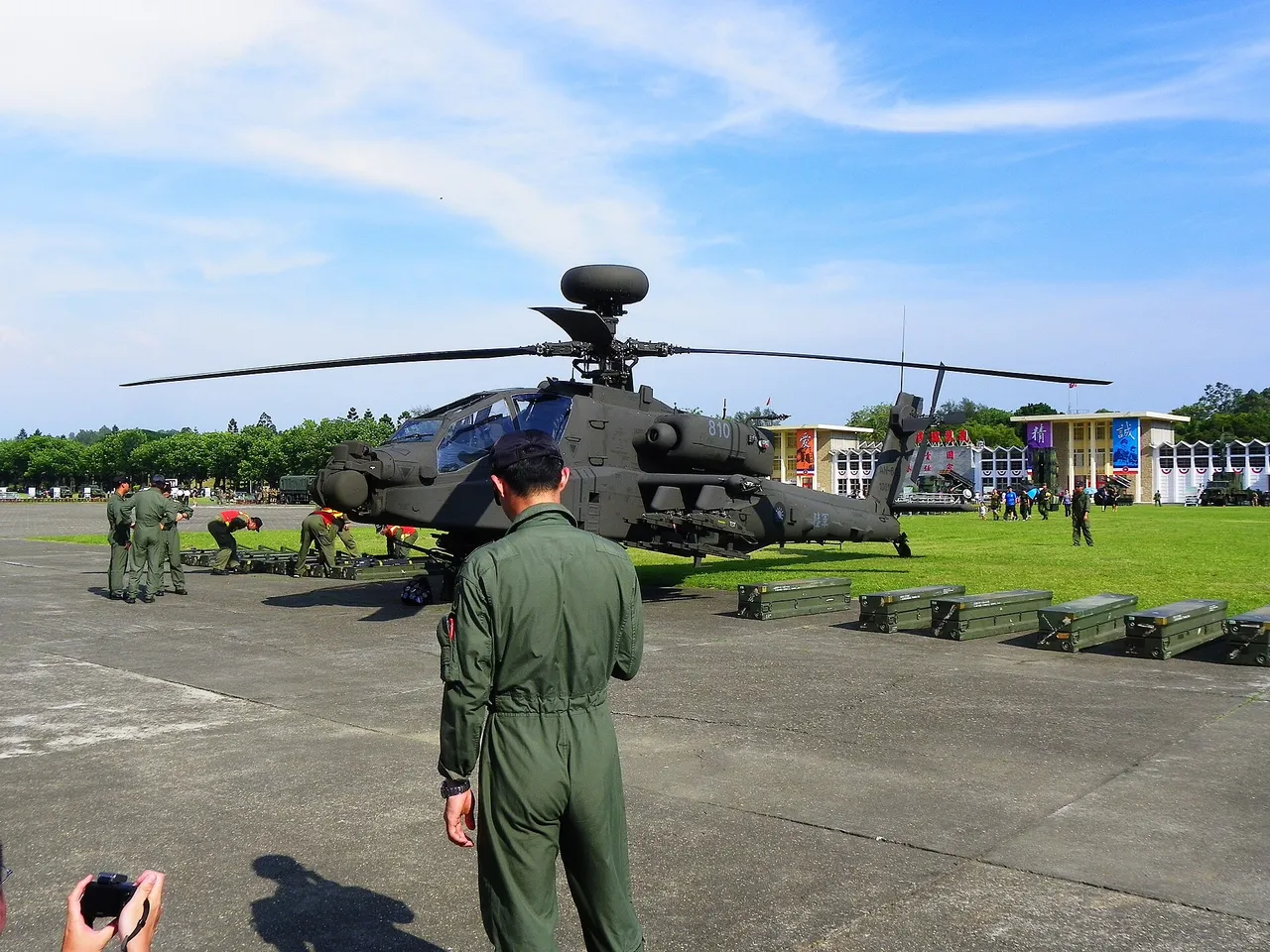 A Taiwanese army AH-64E Apache attack helicopter parked on a tarmac as uniformed crew stand nearby