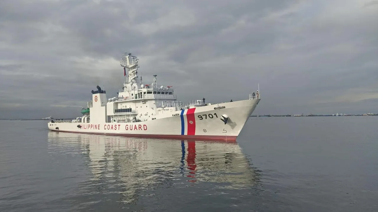 White Philippine Coast Guard patrol ship with hull number 9701 and a blue and red stripe on calm water under a grey sky