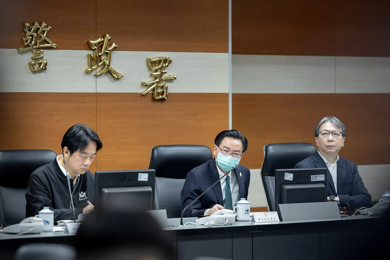 Three officials seated at a briefing table with monitors, under gold characters reading National Police Agency