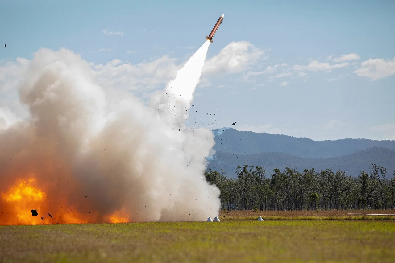 A missile climbs away from a launcher amid a large cloud of white smoke and orange flame on a grassy range