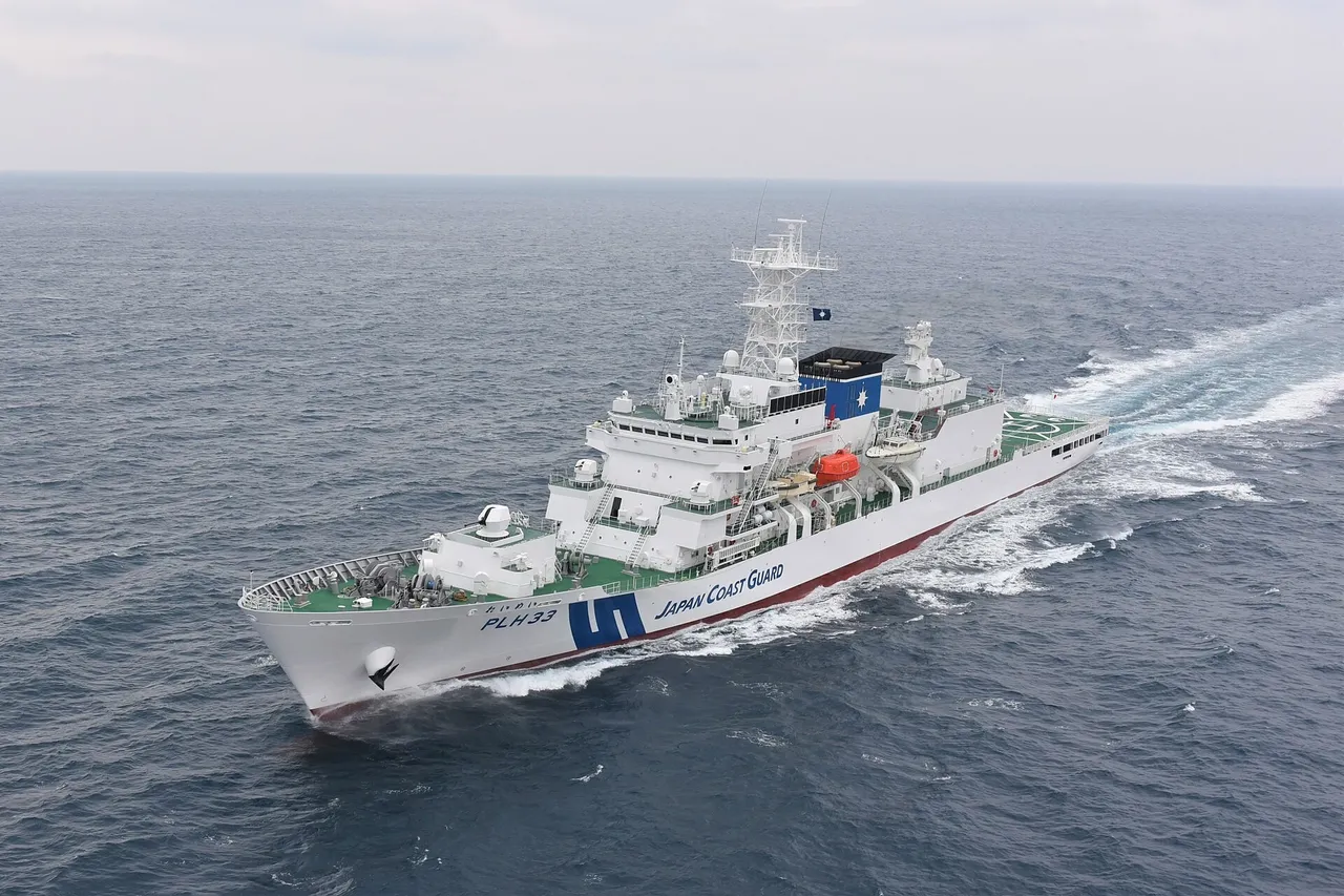 A large white Japan Coast Guard patrol ship with a blue diagonal stripe on its hull at sea
