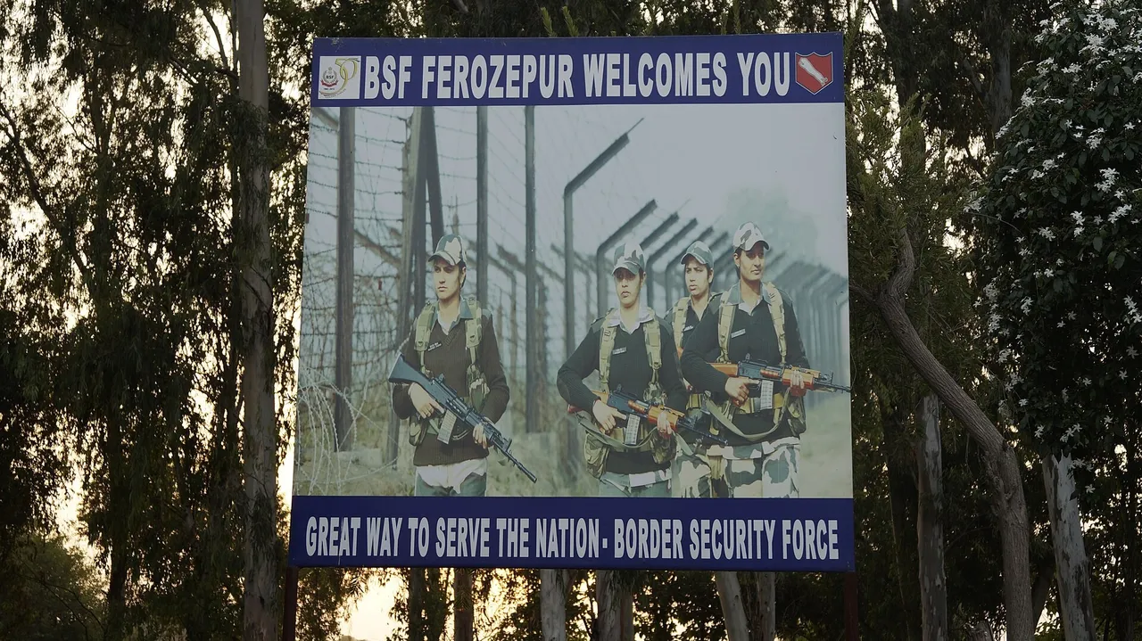 A large roadside billboard reading BSF Ferozepur Welcomes You, showing armed border guards in front of a fence, set among tall trees