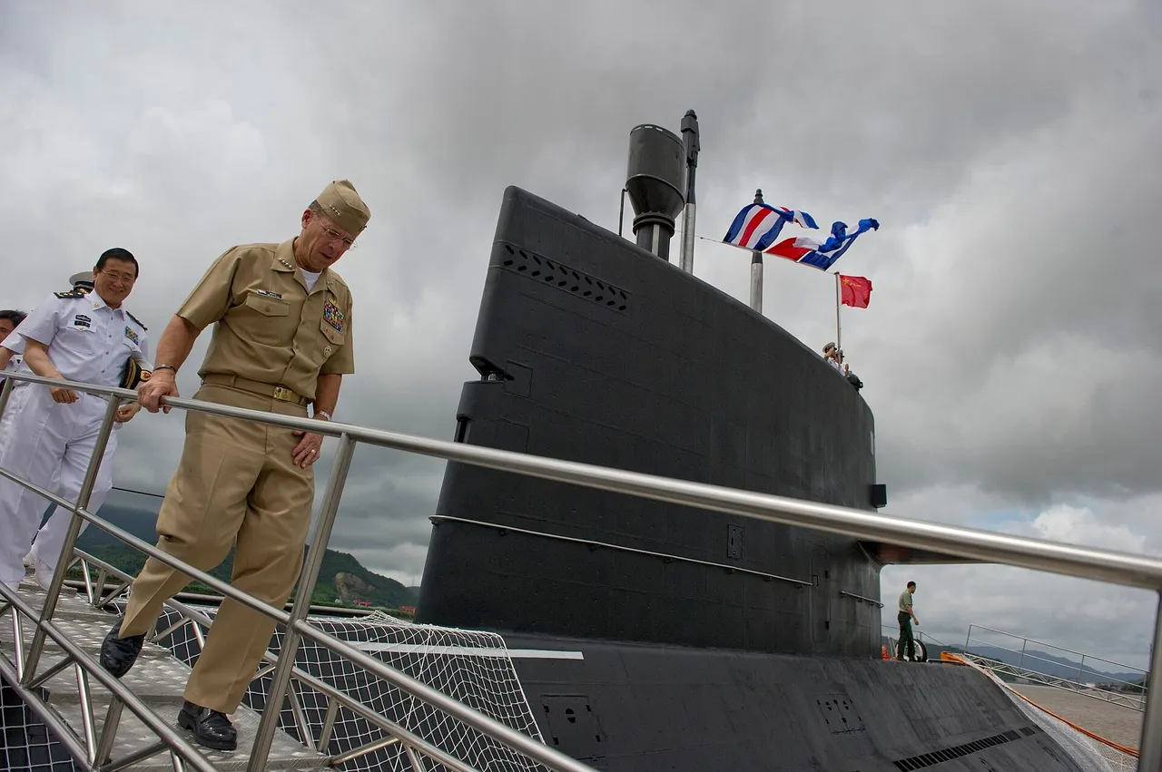 A dark-hulled Chinese diesel-electric submarine moored at a naval pier with sailors standing on its deck