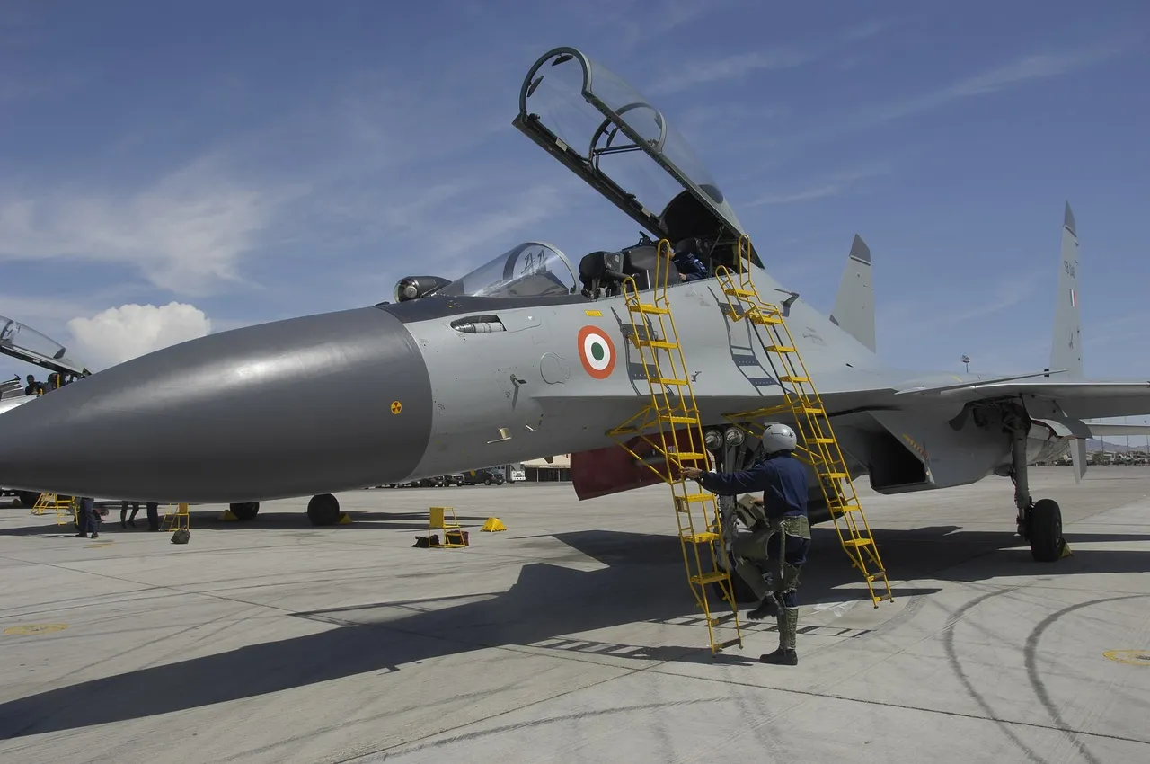 A grey Indian Air Force Su-30MKI fighter with its canopy open and yellow boarding ladders as a crew member climbs up on a sunny flight line