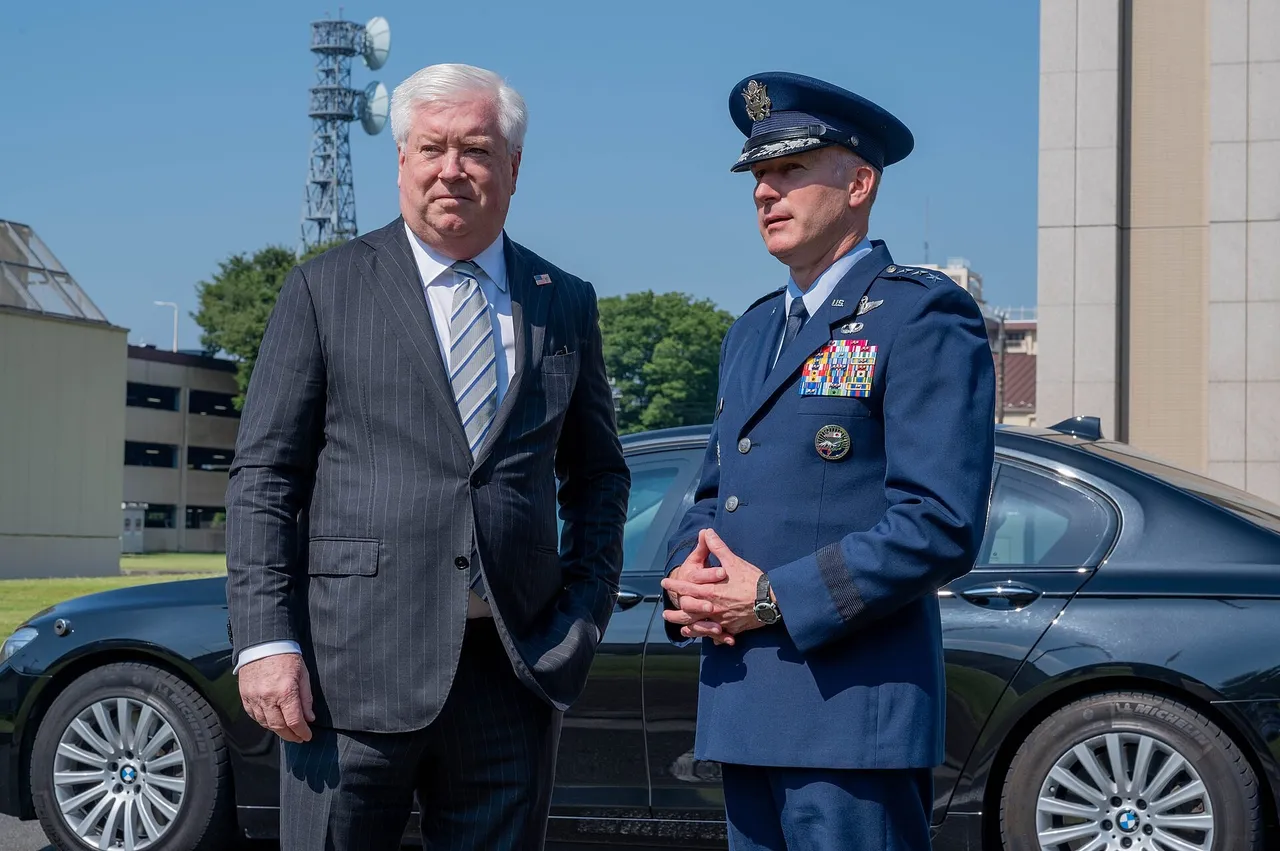 US Ambassador George Glass shaking hands with a US Air Force general in uniform at Yokota Air Base