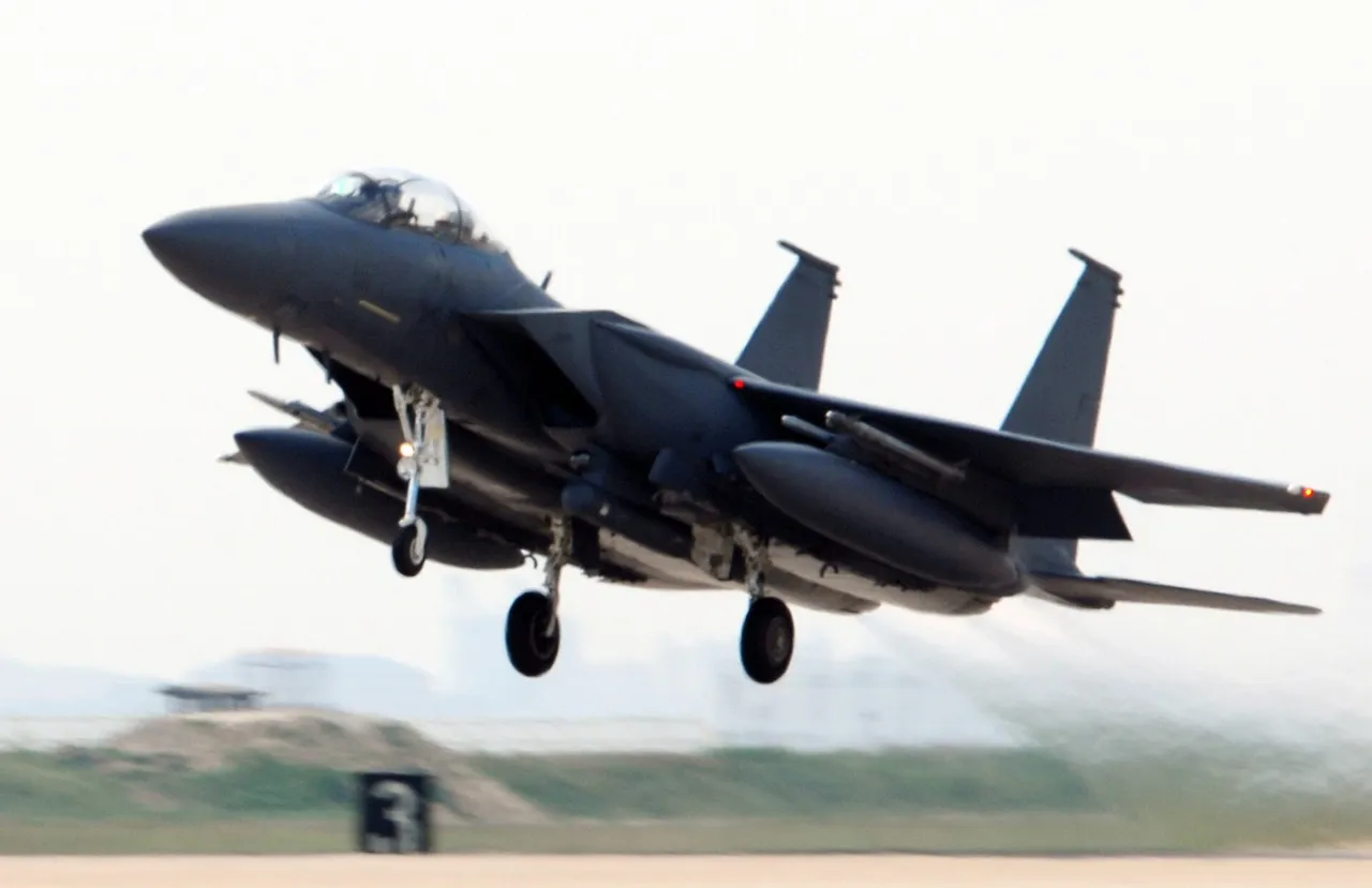 A grey South Korean F-15K fighter jet lifts off a runway with its landing gear down