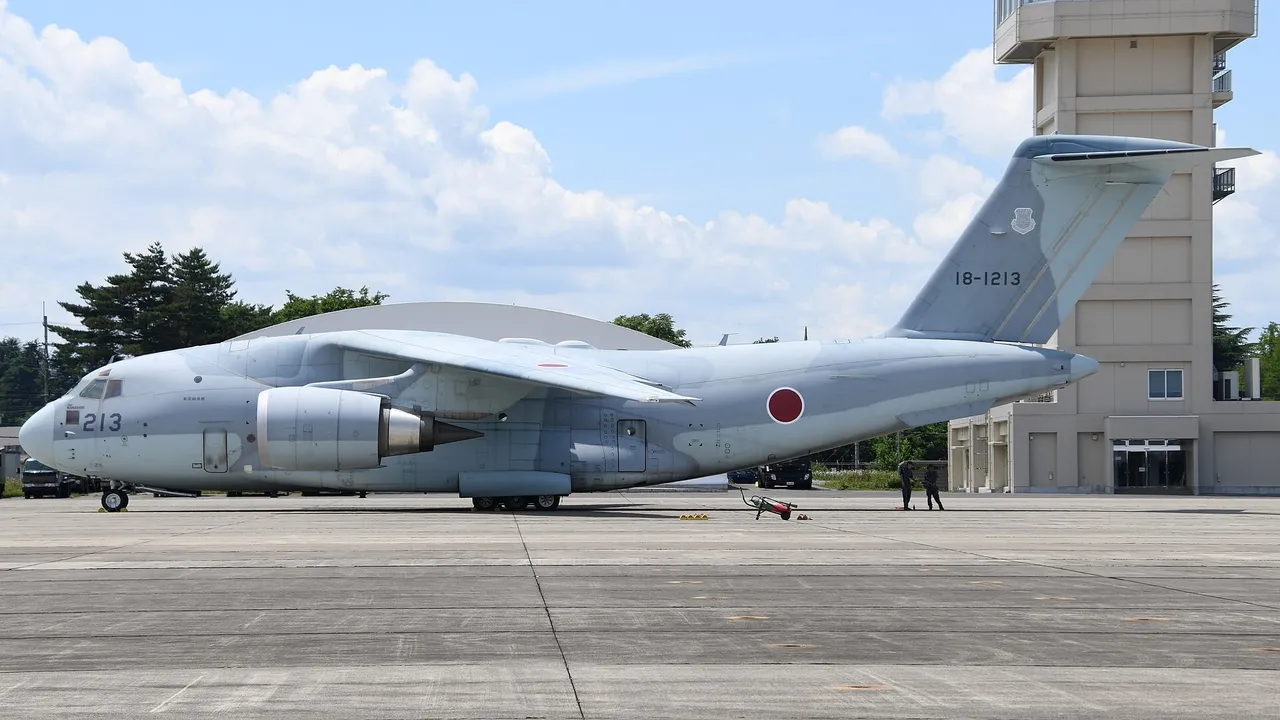 A large grey Japanese military C-2 transport jet parked on the apron at Iruma Air Base, seen from its left side
