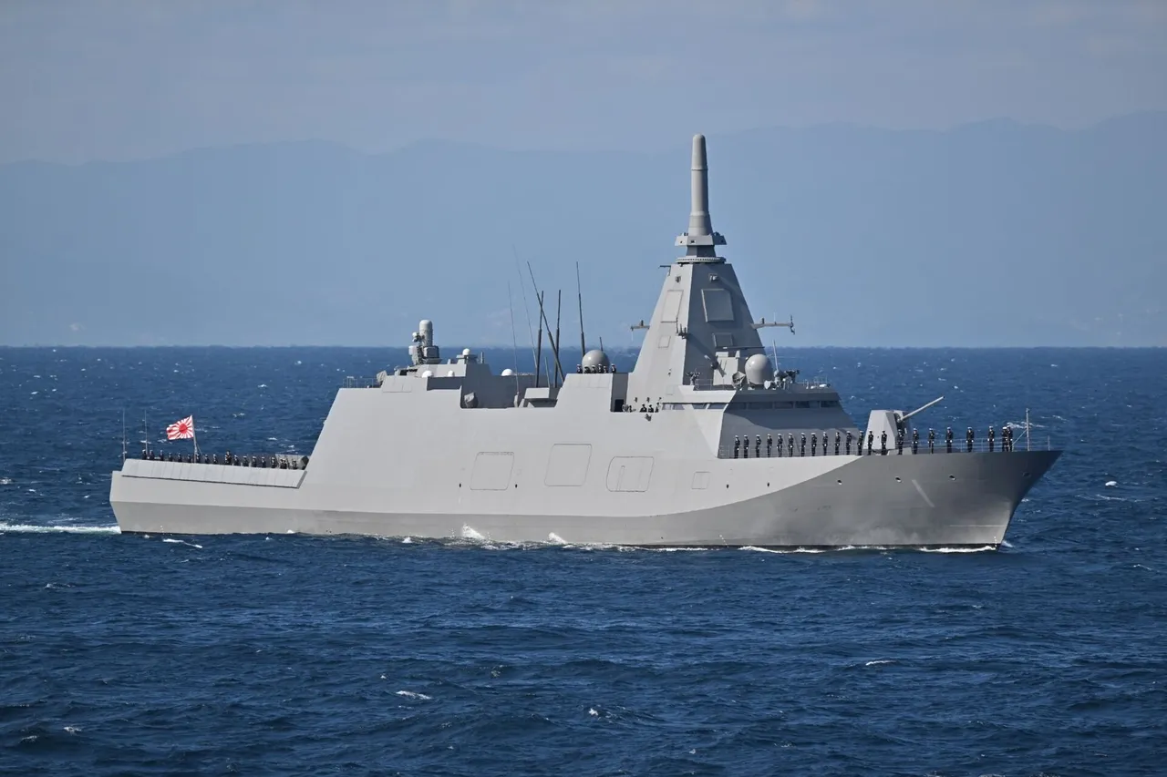 Grey Japanese navy frigate JS Mogami with its angular stealth superstructure sailing at sea