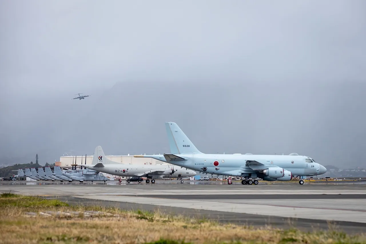 A white South Korean navy P-3 Orion patrol aircraft parked behind a pale blue Japanese P-1 patrol jet on an airfield tarmac under grey skies