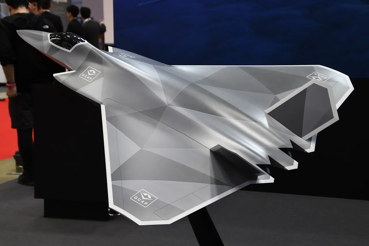 A grey faceted model of a tailless delta-wing stealth fighter on a display stand at a trade show.