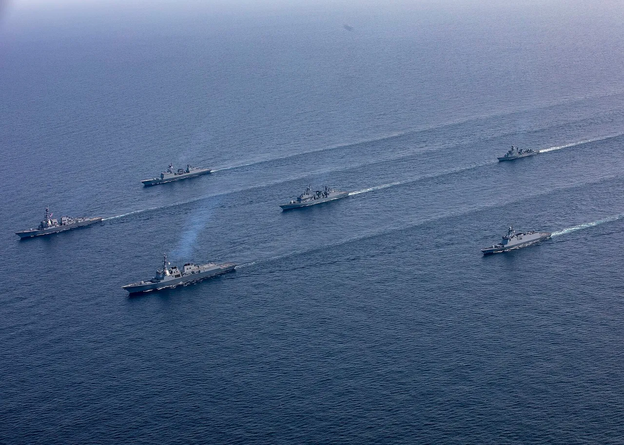 A line of grey warships sailing in formation across open sea