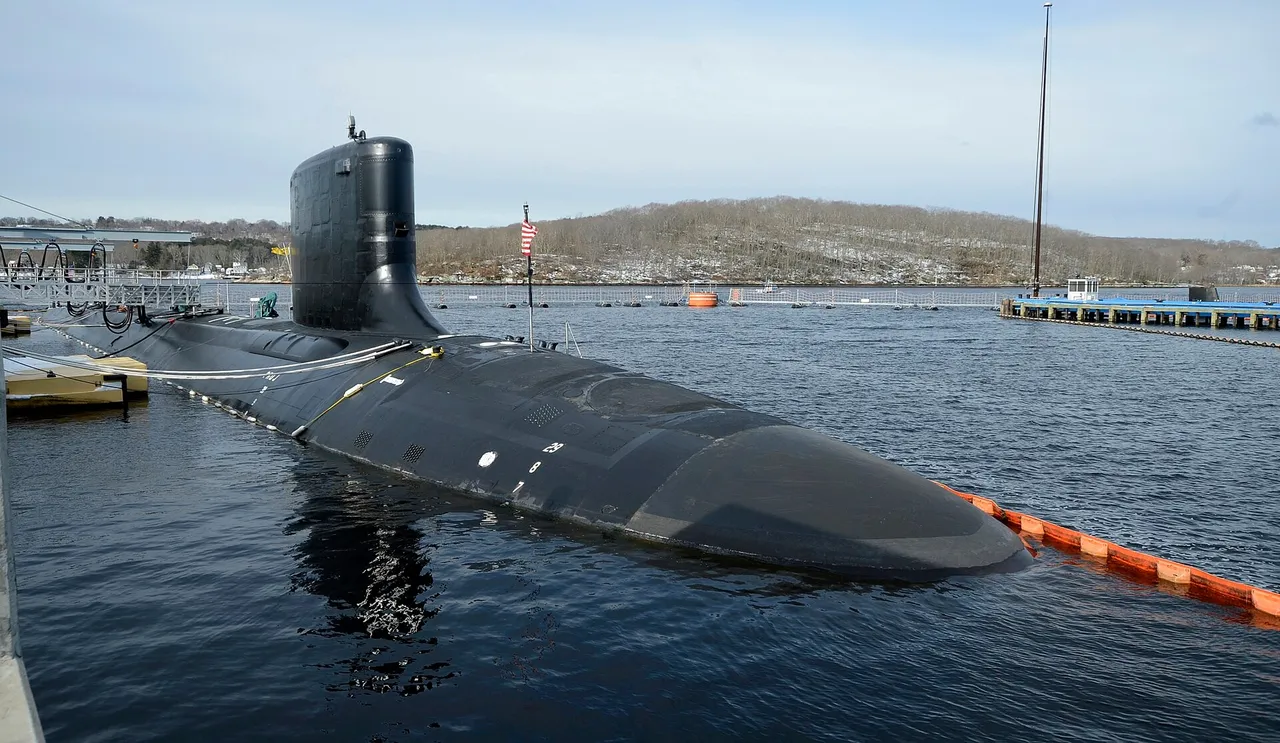 A black Virginia-class submarine moored pierside, its sail and hull visible above the water