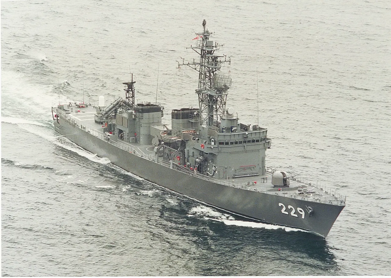 A grey Japanese destroyer escort with hull number 229 sailing at speed on open sea, seen from above