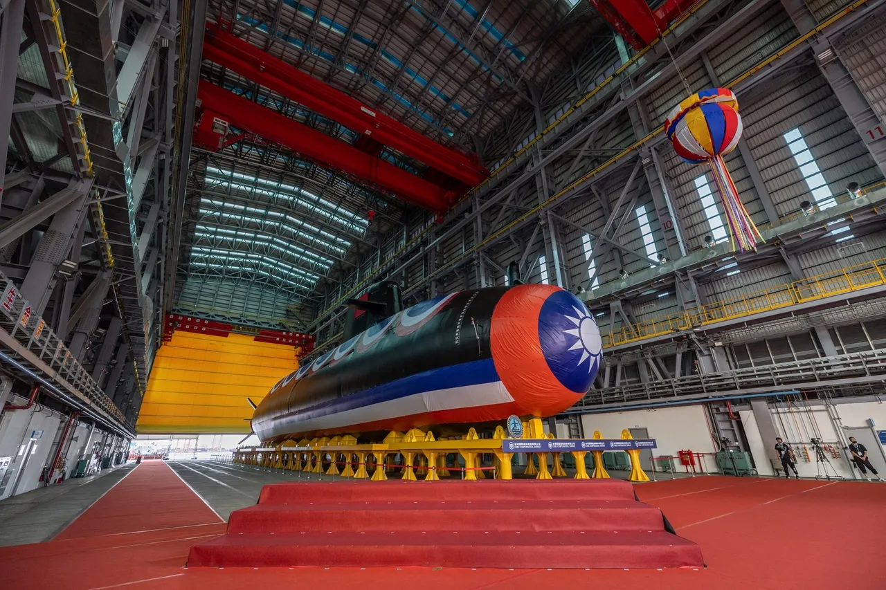 Taiwan's Hai Kun submarine on its cradle inside a shipyard hall, its bow painted in Taiwan's flag colours