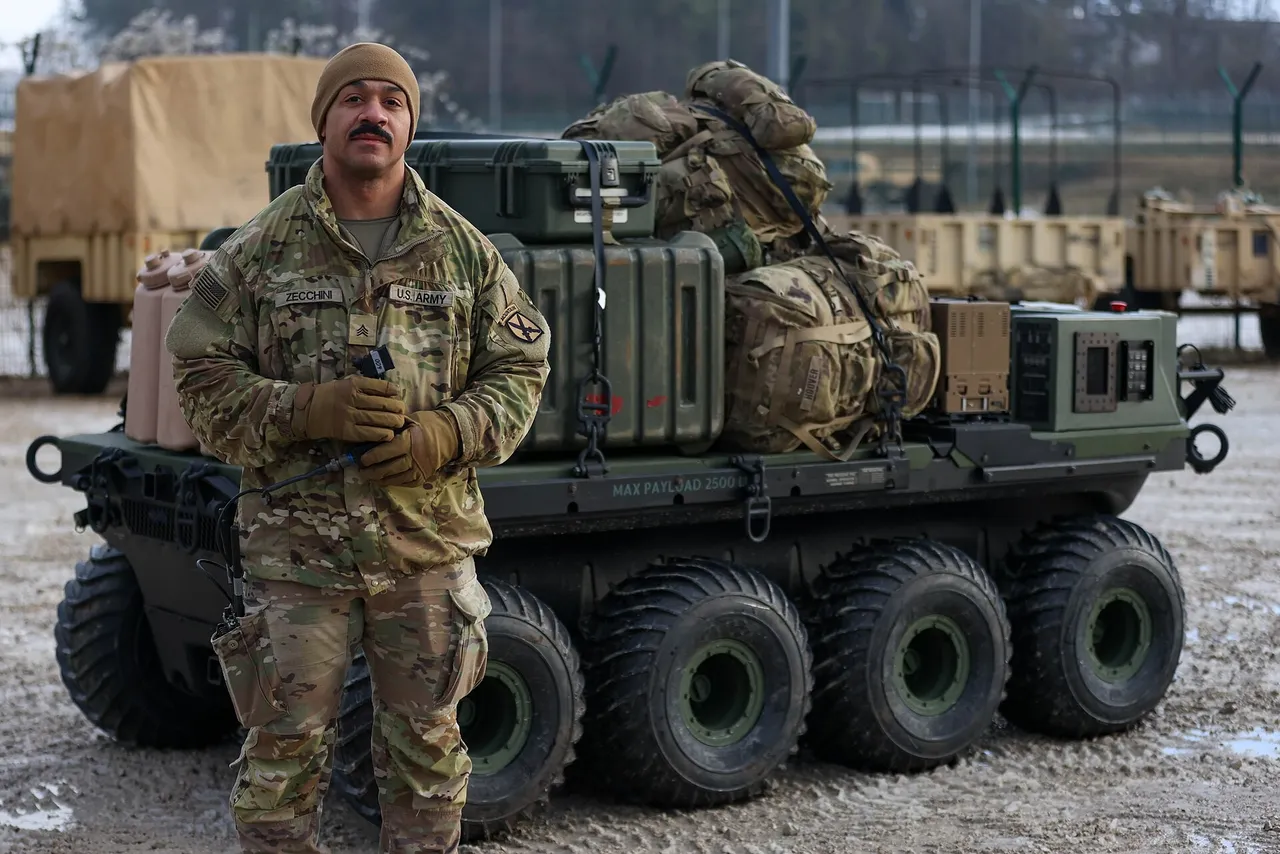 A soldier in camouflage stands before a loaded eight-wheeled robotic cargo vehicle carrying cases and rucksacks