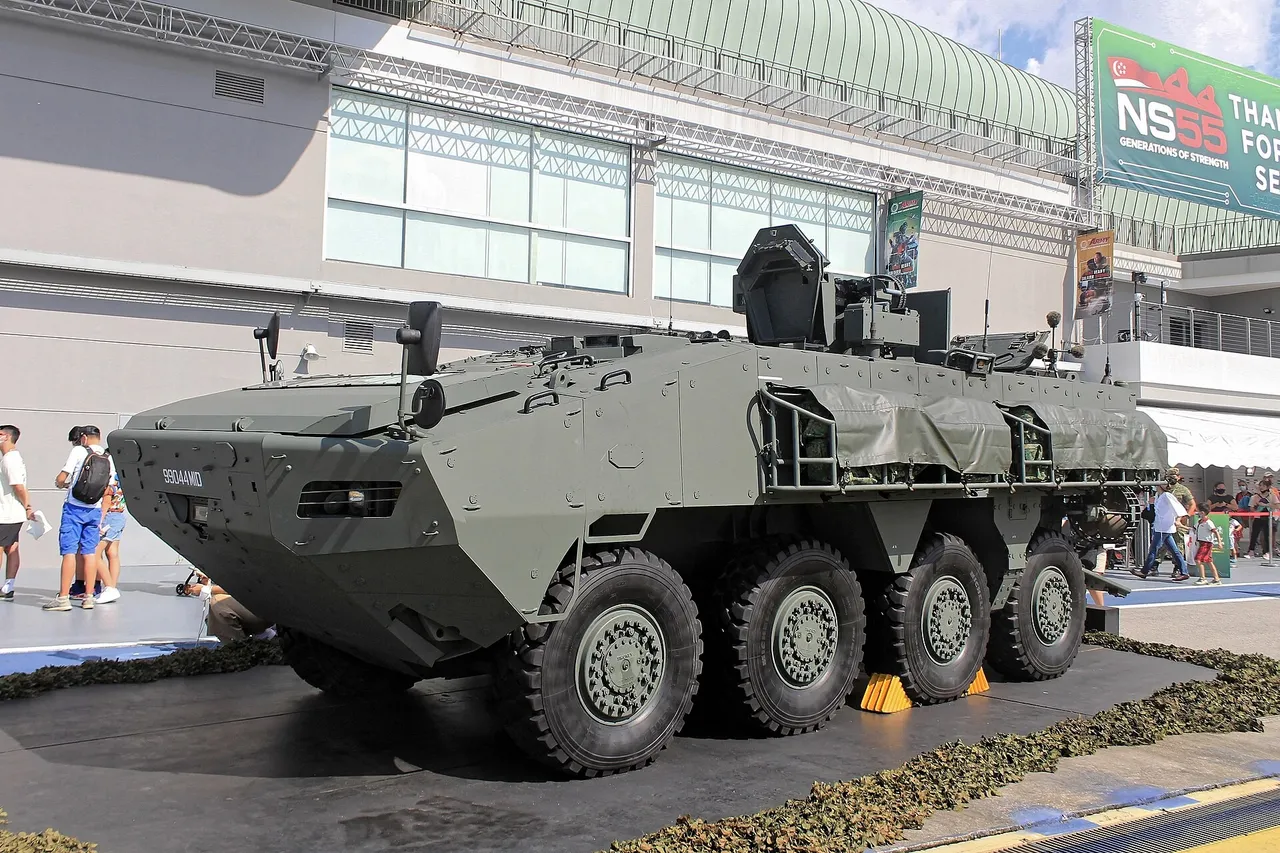 An eight-wheeled Terrex armoured infantry carrier vehicle in camouflage paint parked on display outdoors