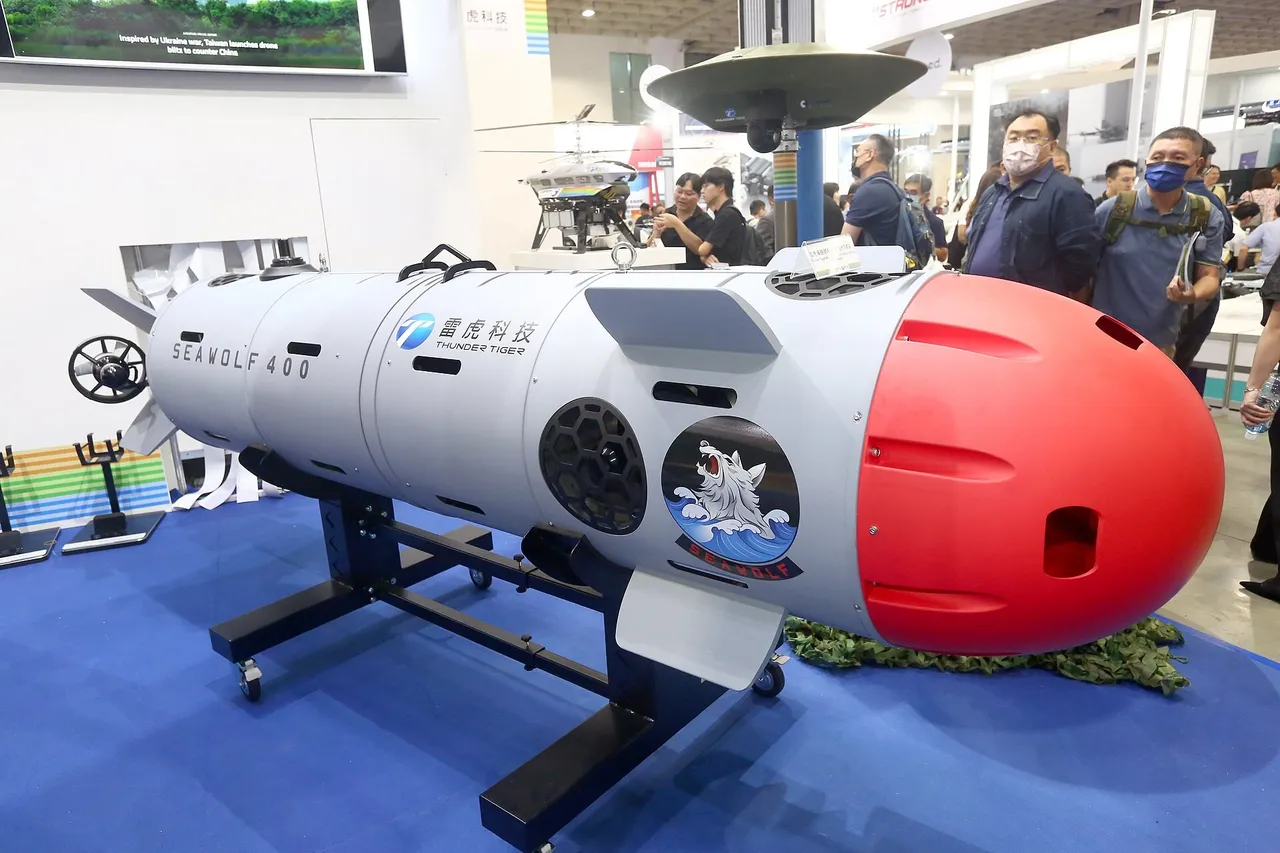White torpedo-shaped Seawolf 400 underwater drone with a red nose cone on a stand at an indoor exhibition, visitors in the background