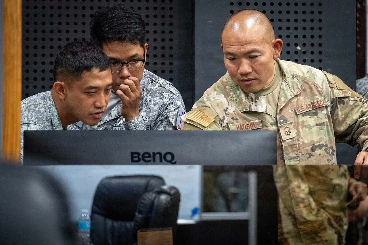 Two Philippine Air Force airmen study a monitor as a US Air Force master sergeant assists during an air defence exercise