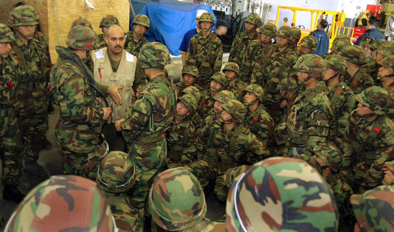 South Korean marines in camouflage uniforms put on orange life jackets on a ship deck