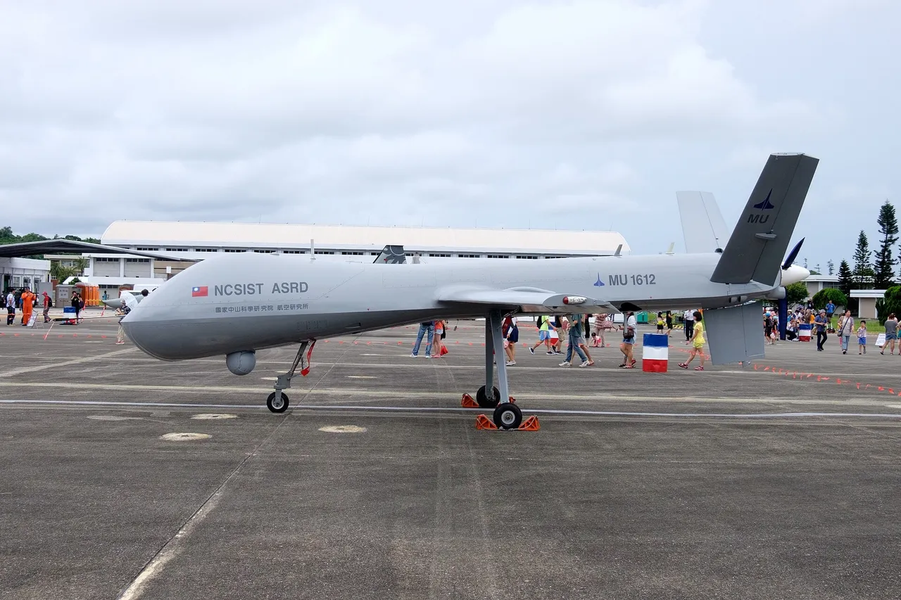 A large grey Teng Yun military drone with a long straight wing parked on an air base apron.