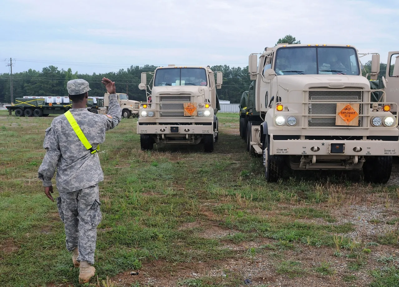 Soldier directing military trucks at an Anniston Army Depot staging area