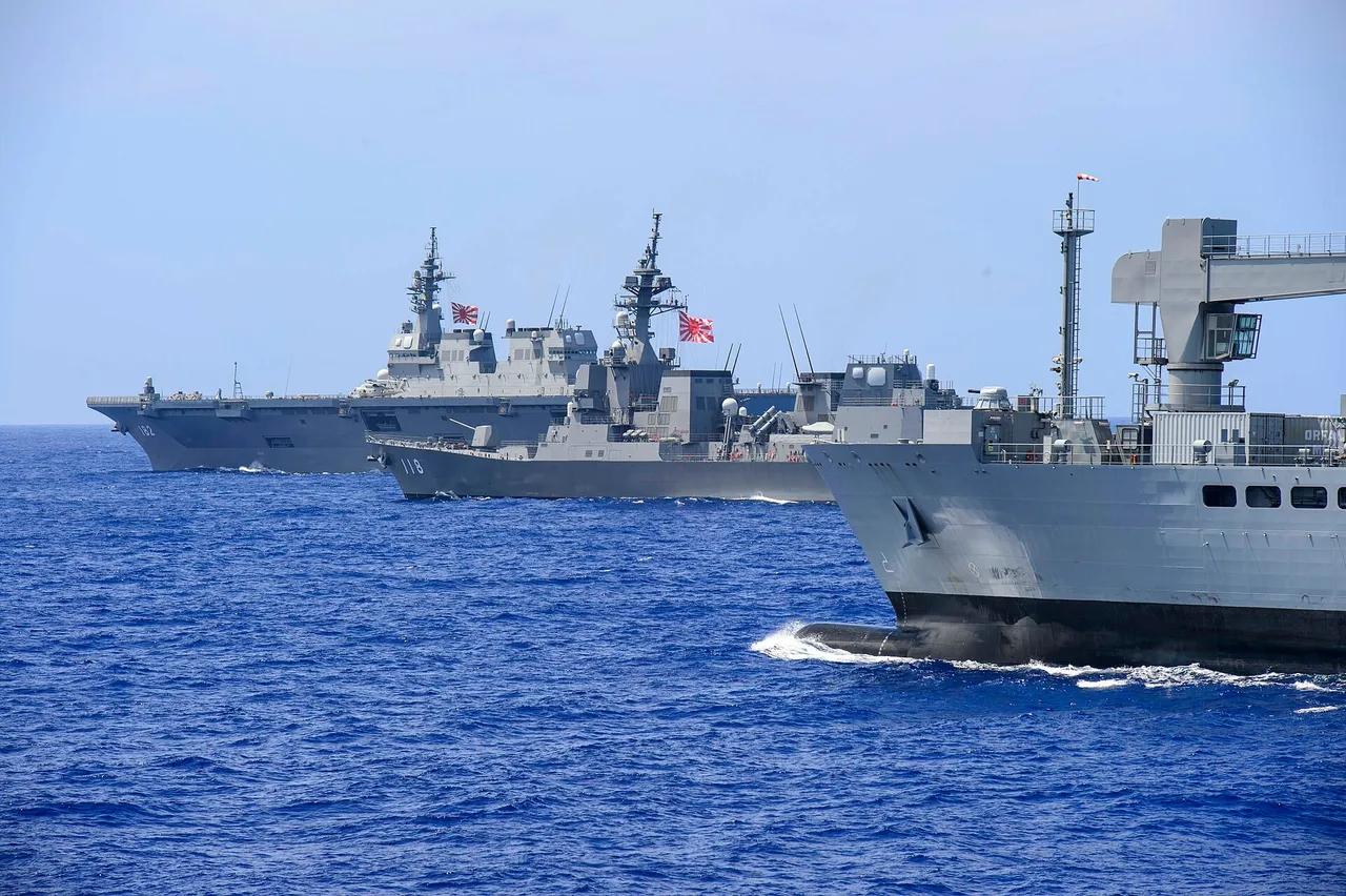 An Indian Navy tanker and two Japanese destroyers sailing in formation at sea