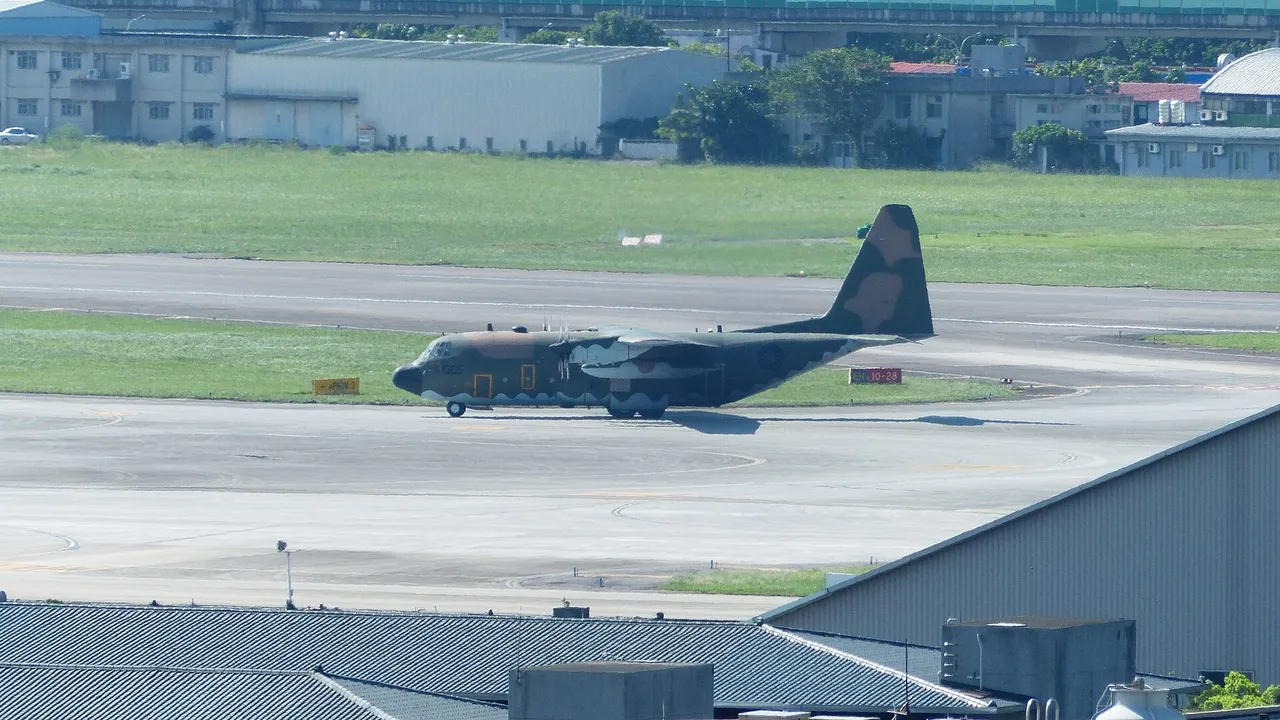 A grey four-engine Taiwanese air force C-130H transport aircraft taxiing on an airfield