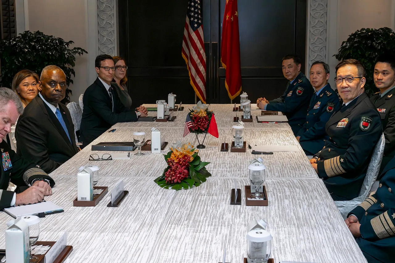Chinese Defence Minister Dong Jun in naval uniform shaking hands with US Defense Secretary Lloyd Austin