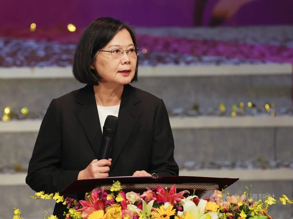 Former President Tsai Ing-wen speaking at a podium with microphone