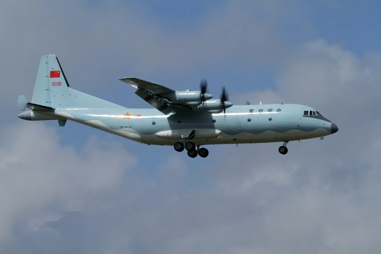 A grey four-engine Chinese military turboprop aircraft landing with its wheels down