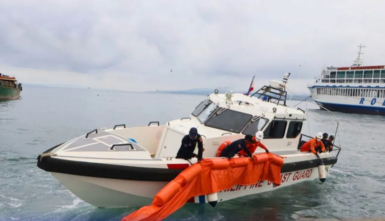A white Philippine Coast Guard high-speed response boat with crew in orange and navy uniforms handling an orange floating boom, with a ferry in the background