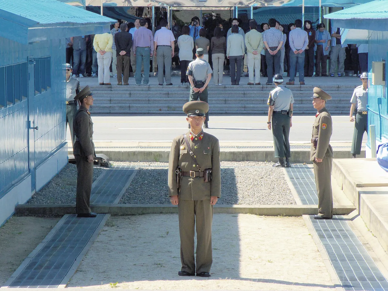 North Korean soldiers stand guard between blue huts at Panmunjom.