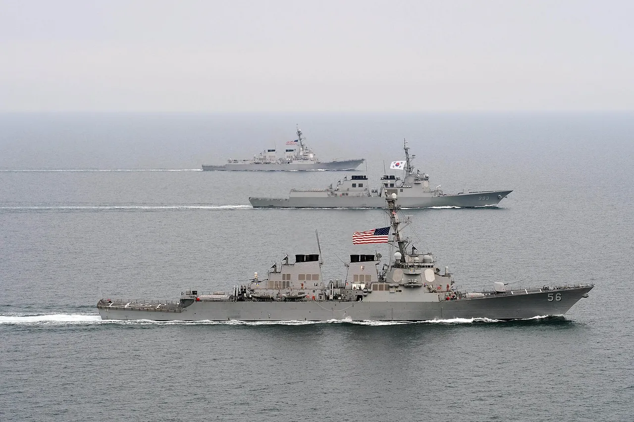 Three grey destroyers sailing in a line across open sea