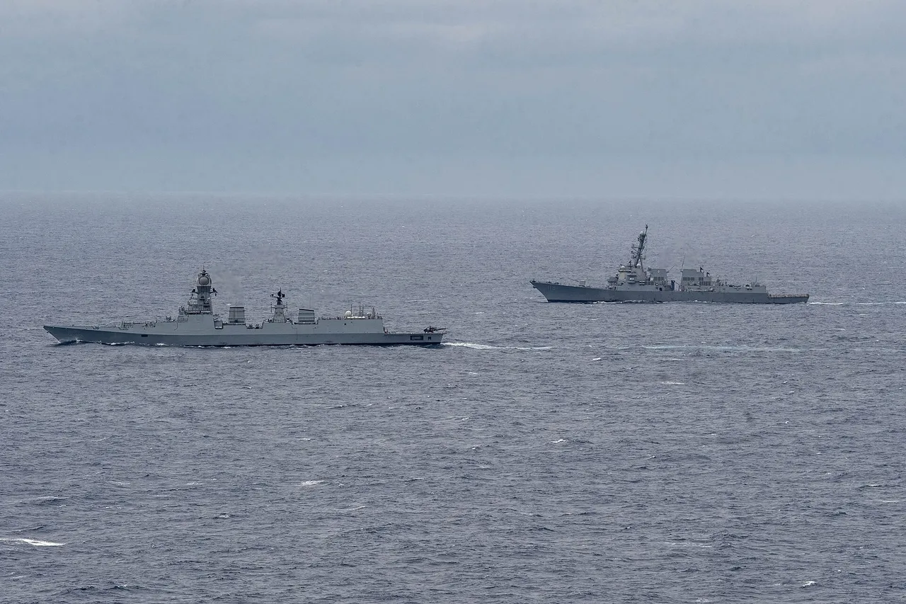 Two grey guided-missile destroyers, an Indian ship on the left and a US ship on the right, sailing side by side on open sea