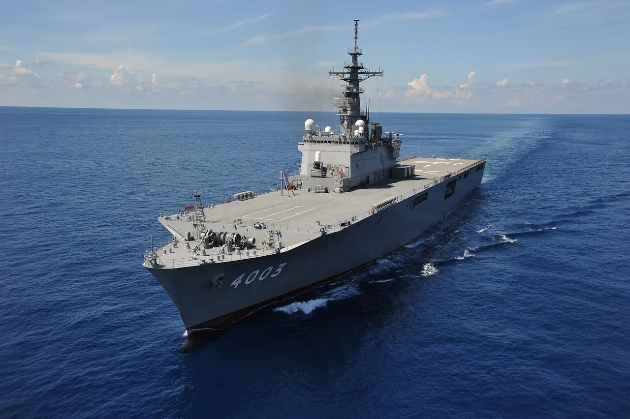 A grey Japanese navy transport ship with a flat deck and the hull number 4003 sails across open blue sea