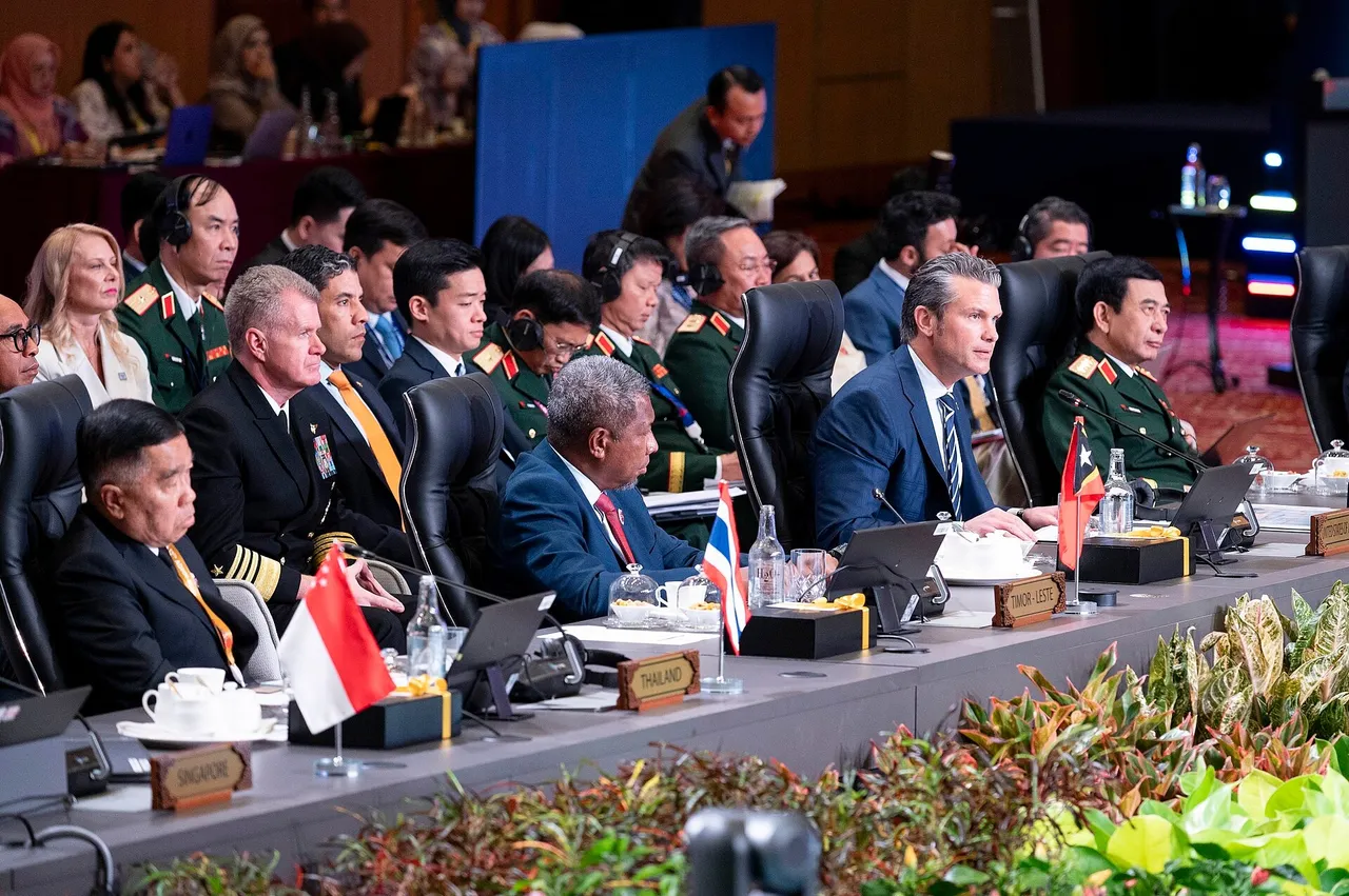 Delegates in suits and military uniforms sit along a conference table with small national flags and name plates