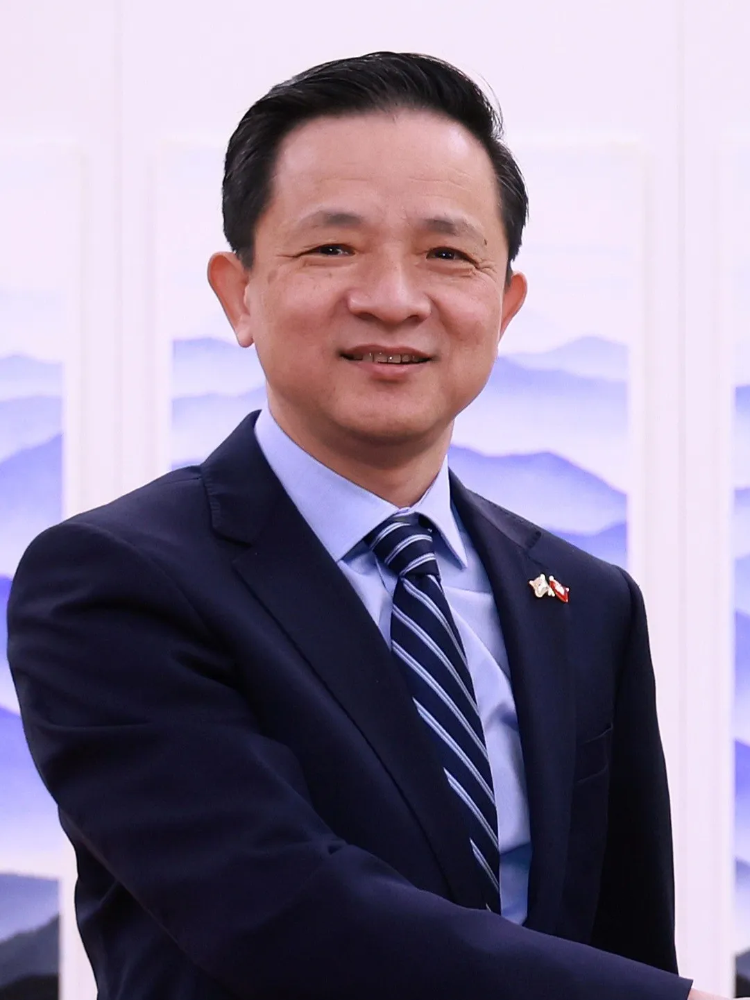 Portrait of a man in a dark suit and tie, China's ambassador to South Korea Dai Bing, standing indoors