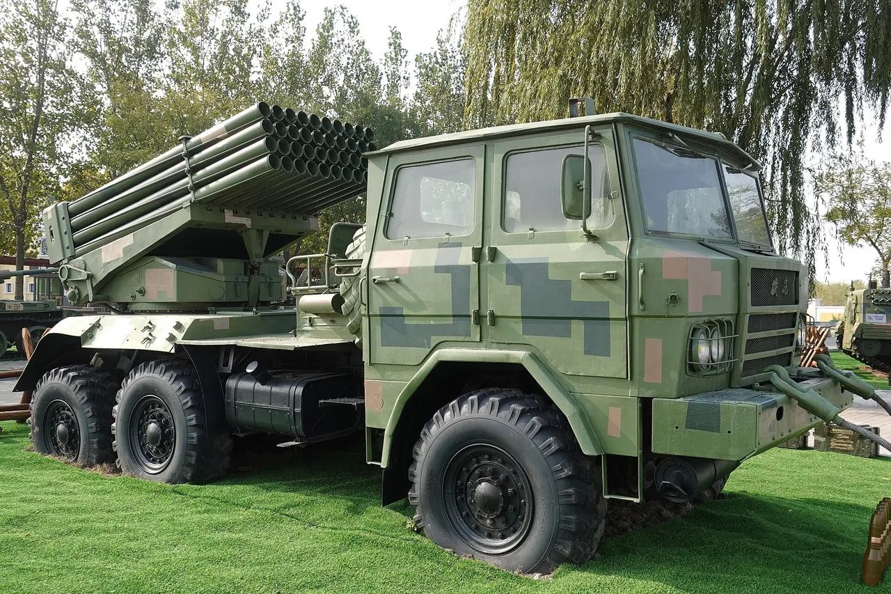 A green camouflaged Chinese Type 81 multiple rocket launcher truck with a bank of 40 rocket tubes, parked on grass