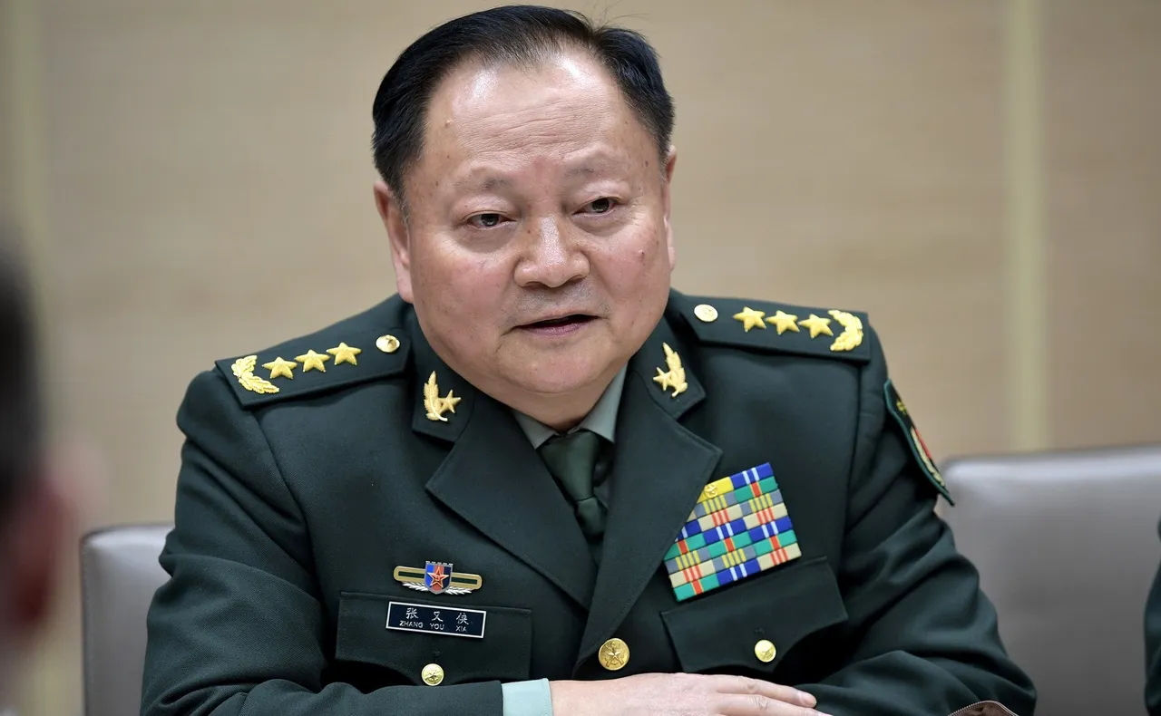 Chinese general Zhang Youxia in a dark green PLA uniform with general's stars on the shoulders, speaking at a meeting table
